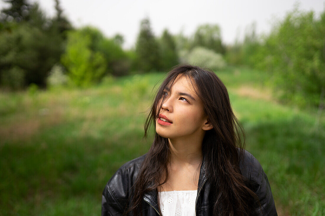 Portrait eines Mädchens (16-17), das im Wald nach oben schaut