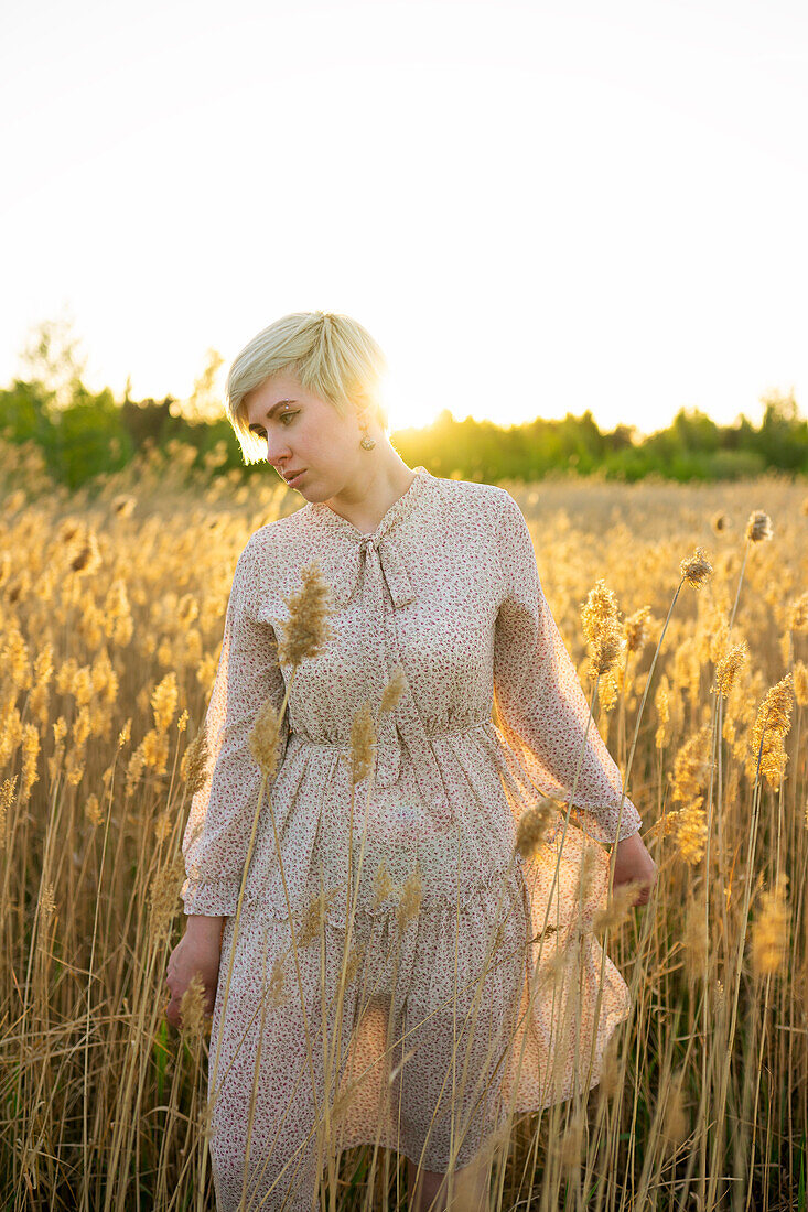 Portrait of woman walking in field at sunset