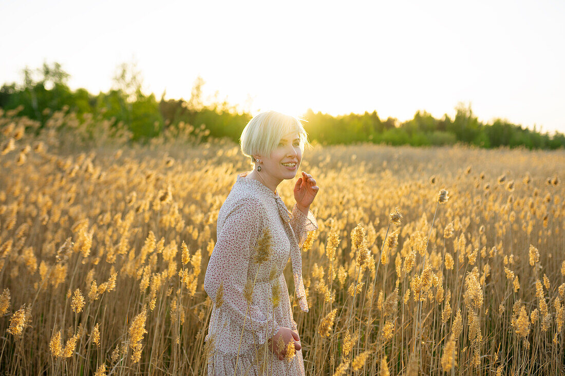 Portrait einer Frau im Feld stehend bei Sonnenuntergang
