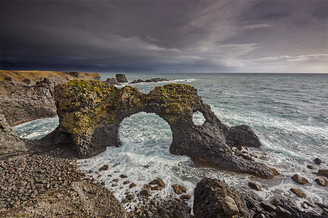 Ein riesiger Lavabogen, von der Brandung des Atlantiks umspült, bei Arnastapi, im Snaefellsjokull-Nationalpark, auf der Halbinsel Snaefellsnes, Westküste Islands, Polarregionen