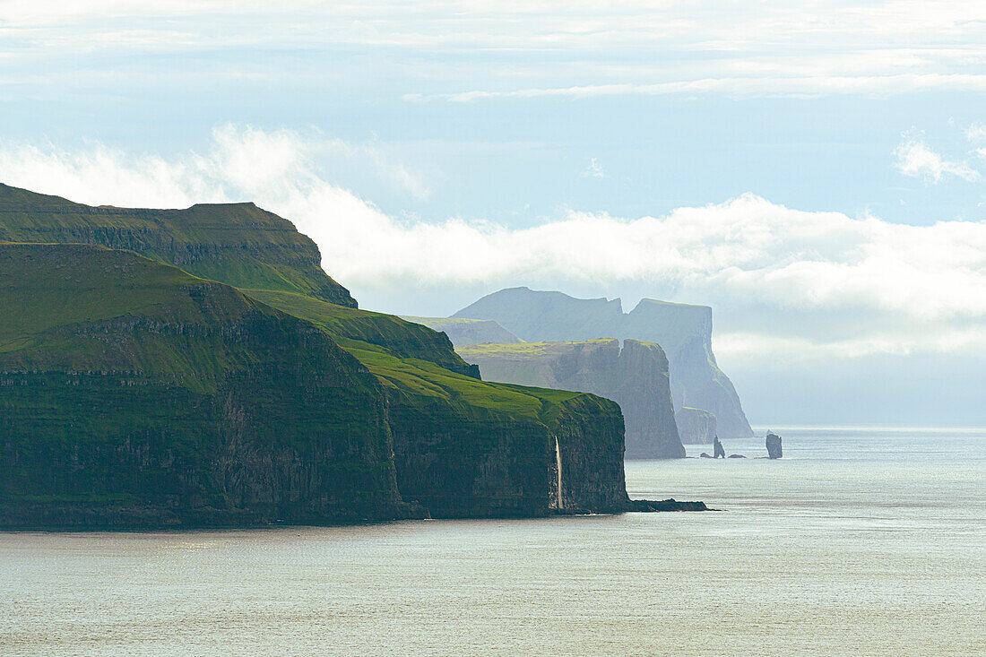 Overview of majestic cliffs overlooking the Atlantic Ocean from Kallur lighthouse, Kalsoy island, Faroe Islands, Denmark, Europe