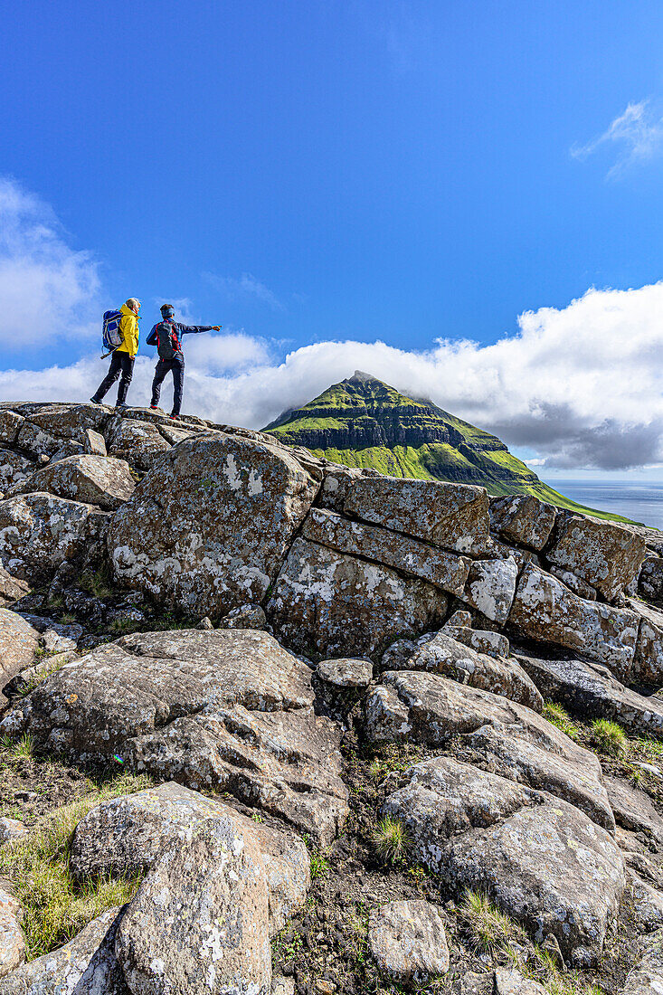 Tourists looking at the fjord during a hike to Skaelingsfjall mountain in summer, Streymoy Island, Faroe Islands, Denmark, Europe
