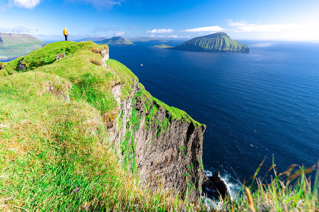 Eine Person bewundert die Aussicht auf den Klippen über dem Meer, Nordradalur, Streymoy Island, Färöer Inseln, Dänemark, Europa