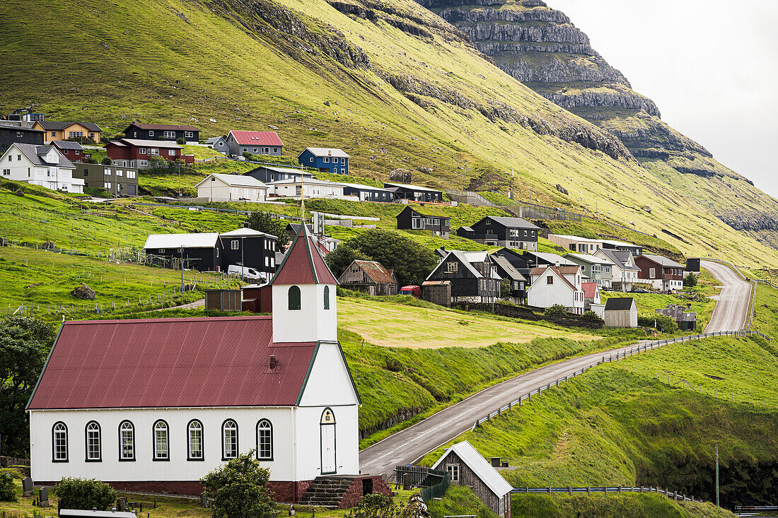 Traditionelle Häuser und Kirche im Küstendorf Kunoy im Sommer, Insel Kunoy, Färöer Inseln, Dänemark, Europa