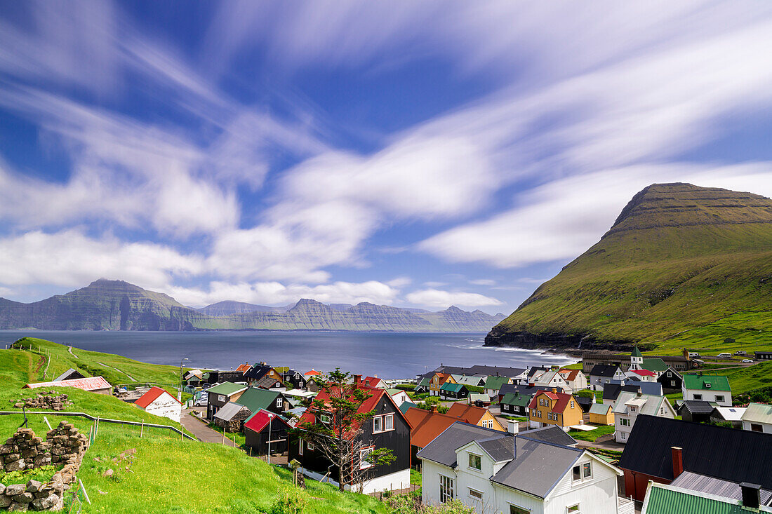 Fluffy clouds in the summer sky over the traditional houses of Gjogv, Eysturoy Island, Faroe Islands, Denmark, Europe