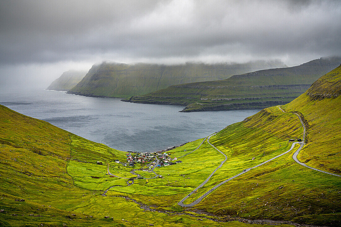 Storm clouds over the coastal village of Funningur along the fjord, Eysturoy Island, Faroe Islands, Denmark, Europe