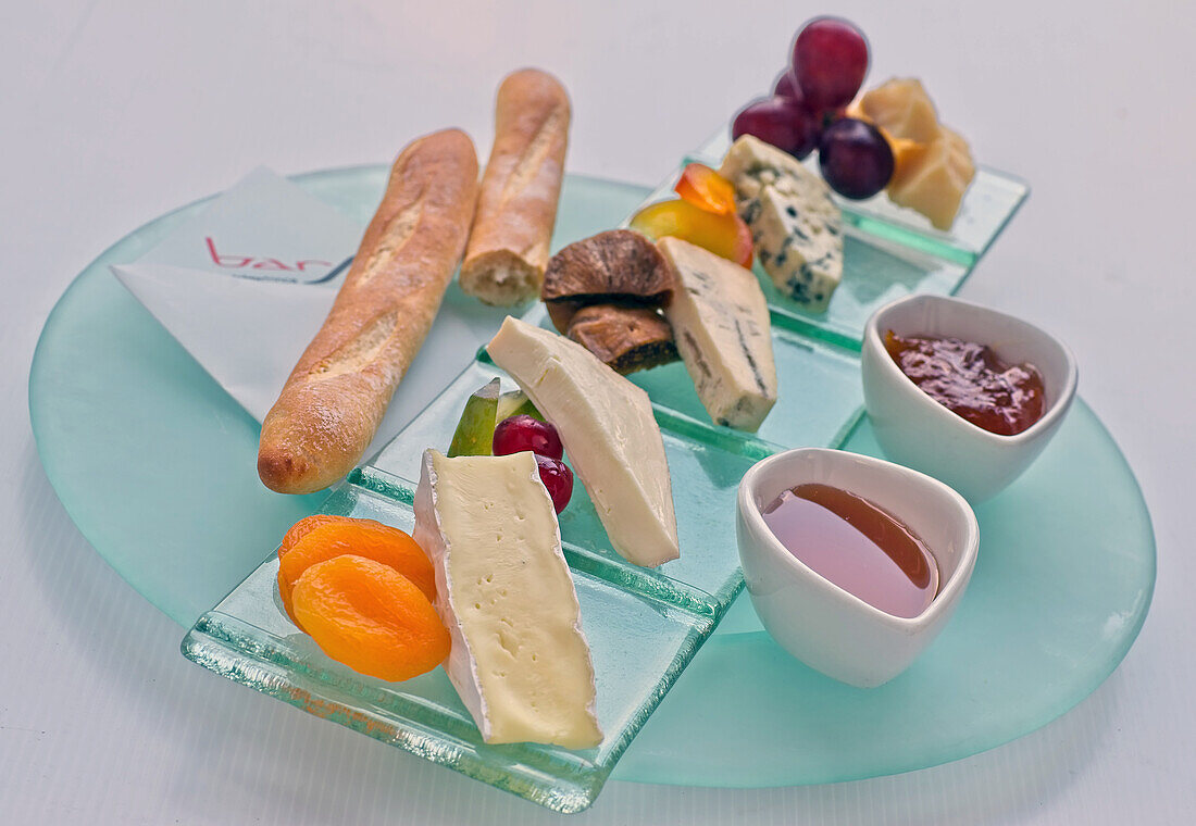Cheese platter with fruit, jams and baguette