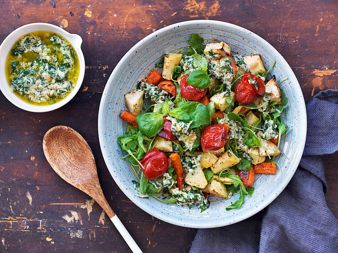 Warm salad with baked root vegetables, arugula, basil, tomatoes, and pesto