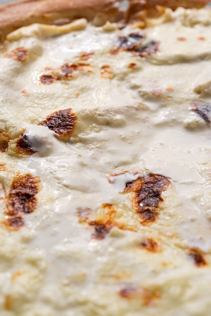 Dünner Pizzaboden mit cremigem Käse