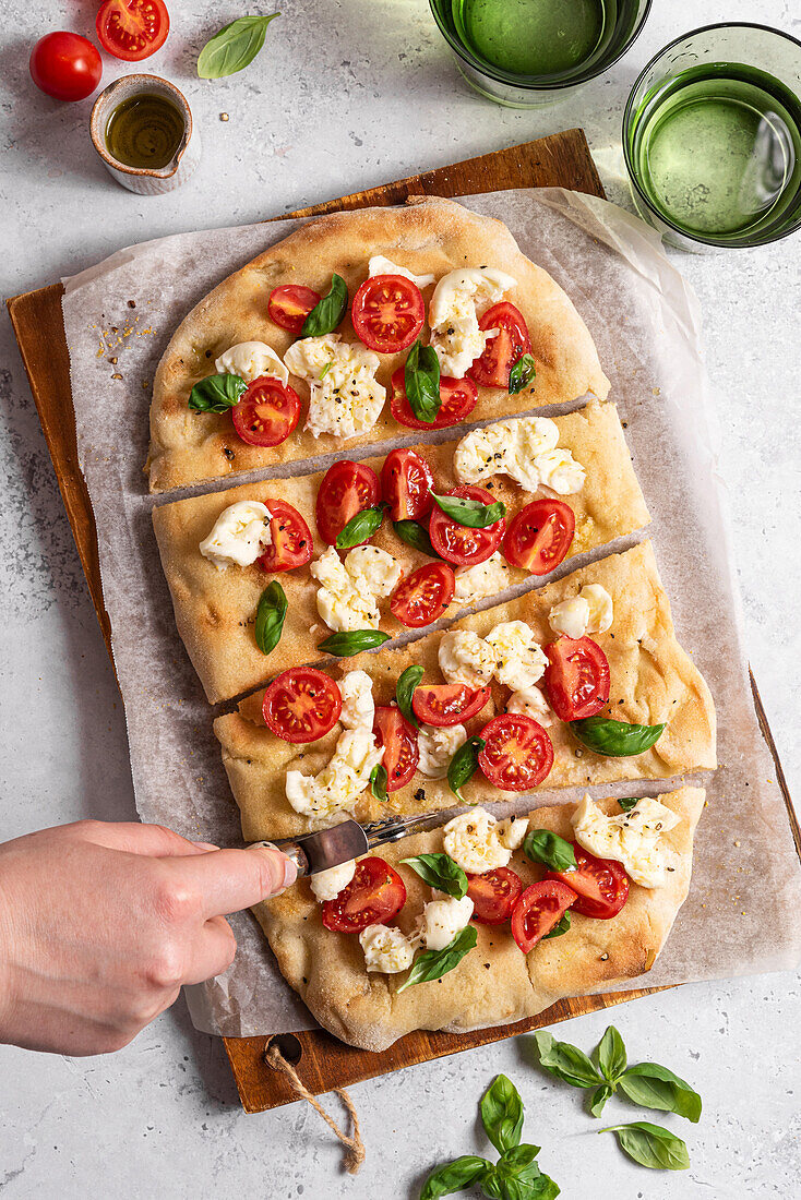 Pinsa mit Tomaten, Mozzarella, Basilikum und Olivenöl