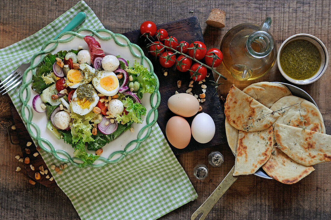 Gemischter Salat mit gekochten Eiern, Mozzarellabällchen und Pesto
