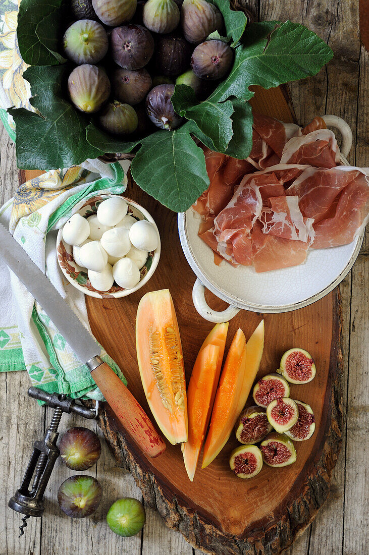 Zutaten für Antipasti: Feigen, Parmaschinken, Melone und Mozzarellabällchen