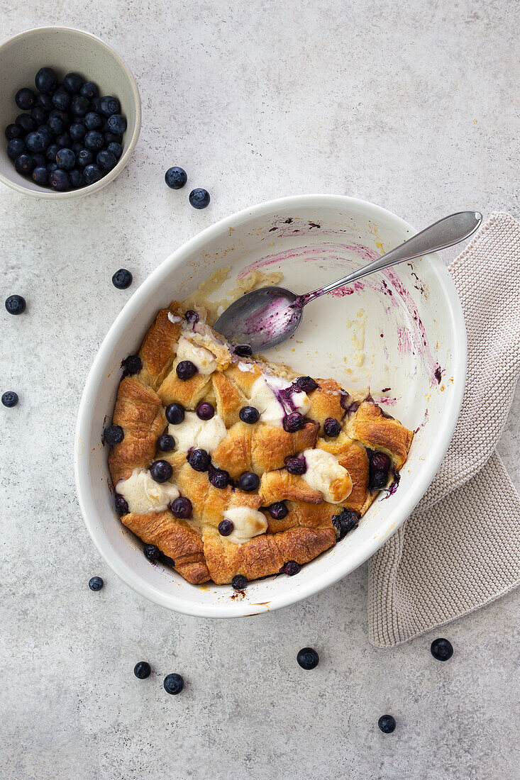 Breakfast casserole of croissants with blueberries and vegan 'cream cheese' blobs