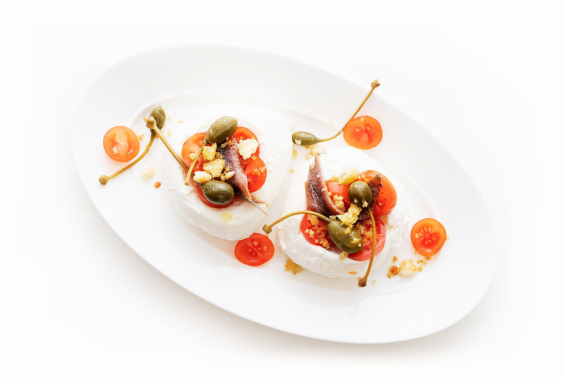 Mozzarella stuffed with anchovies, cherry tomatoes and capers