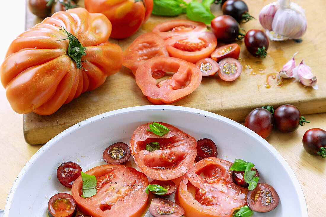 Tomaten (Ochsenherzen und Black Lady) in Scheiben geschnitten mit Basilikum und Knoblauch