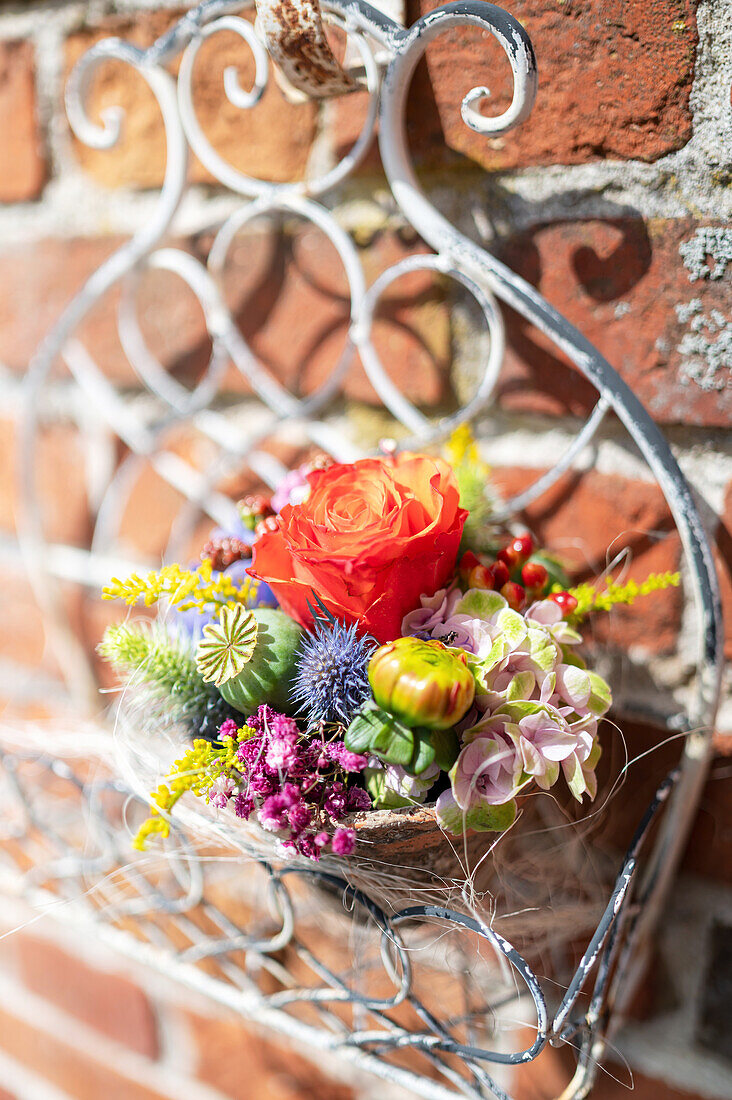 Colorful summer flowers in shabby clay pots on a wall shelf