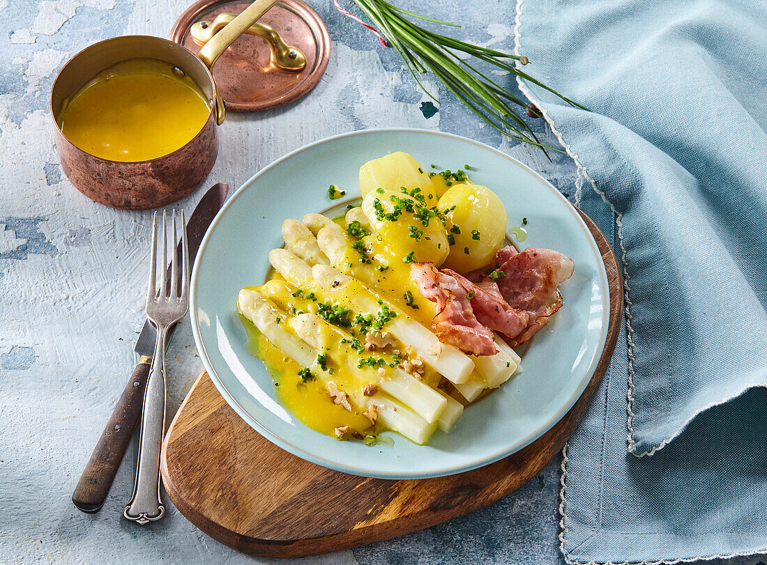 White asparagus with hollandaise sauce and crispy bacon