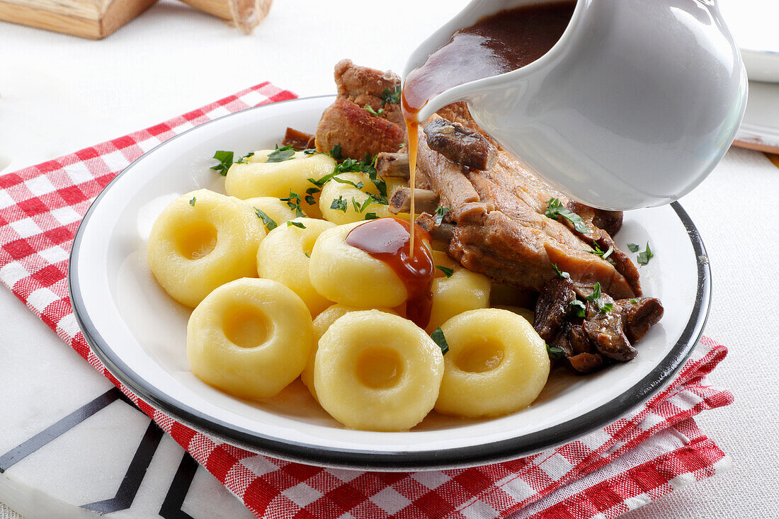 Silesian potato dumplings with gravy and pork neck cutlet