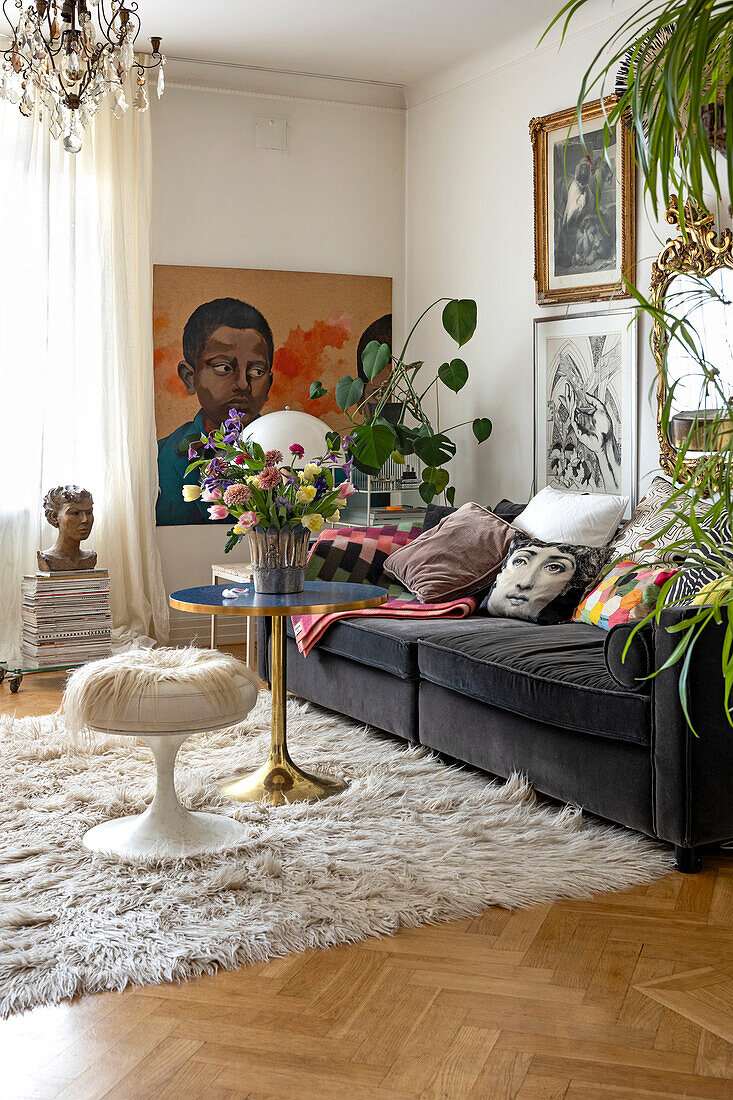 Living room with artwork, dark sofa and fluffy rug