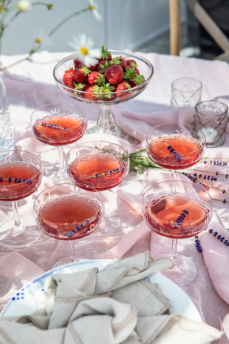 Laid garden table with strawberries and summer drinks