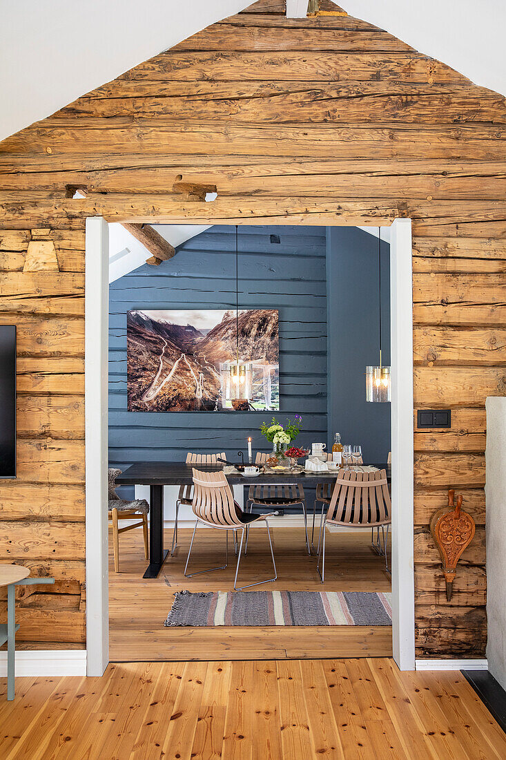 View of dining room with wood panelling and modern chairs