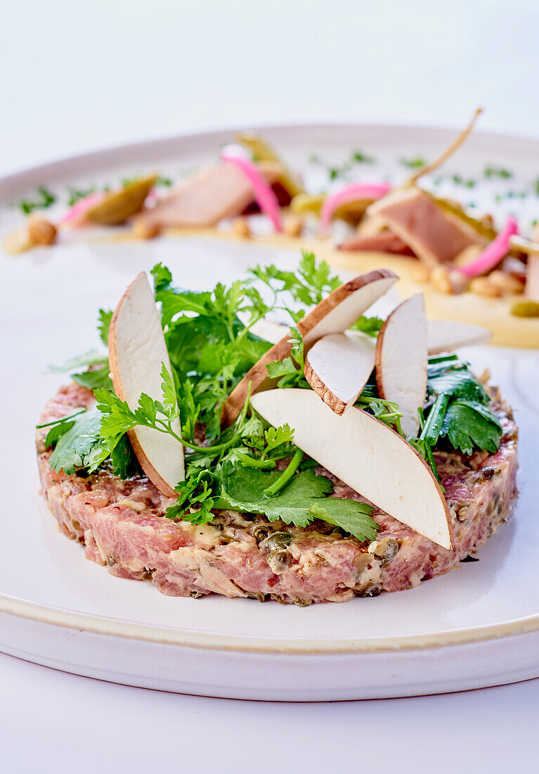 Veal tartare with sweet potatoes and walnuts topped with greens