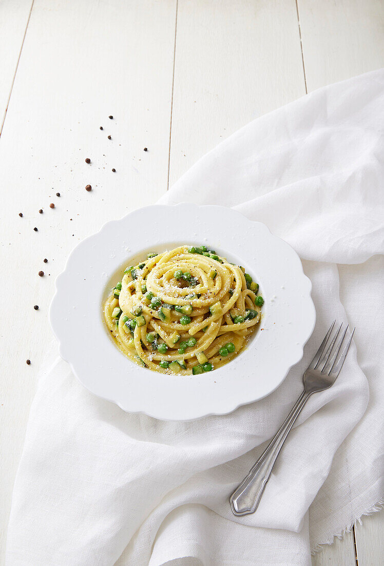 Bucatini mit vegetarischer Carbonara, Zucchini und Erbsen