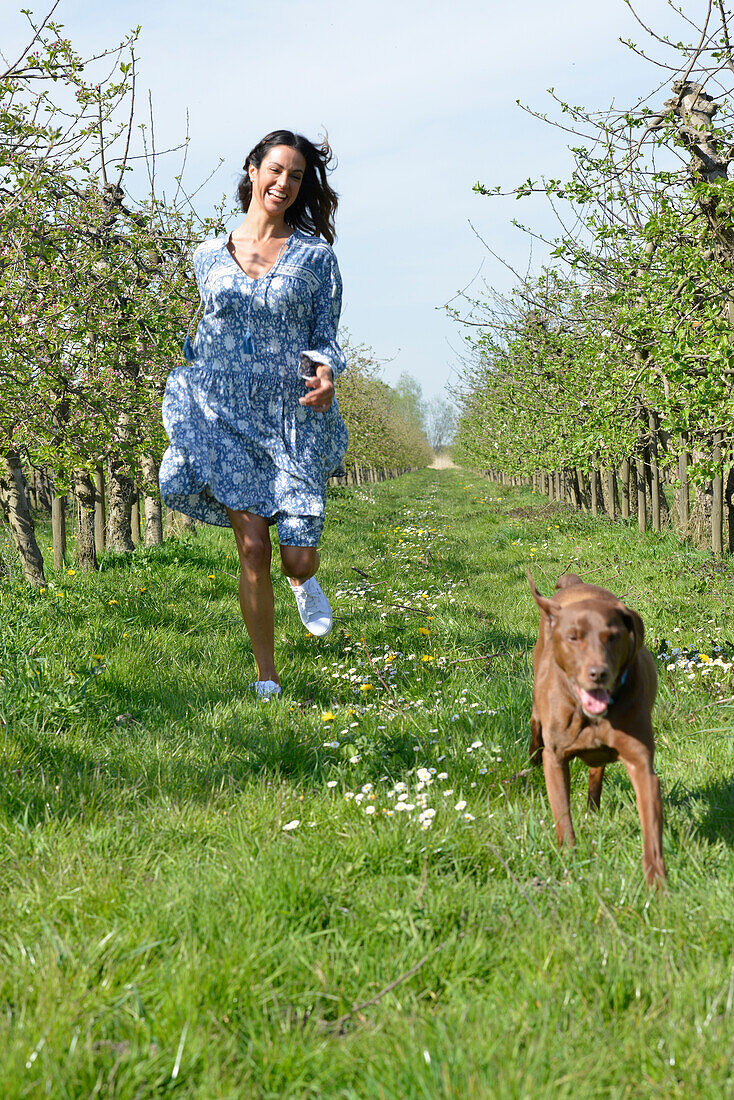 Brünette Frau mit Hund im Garten