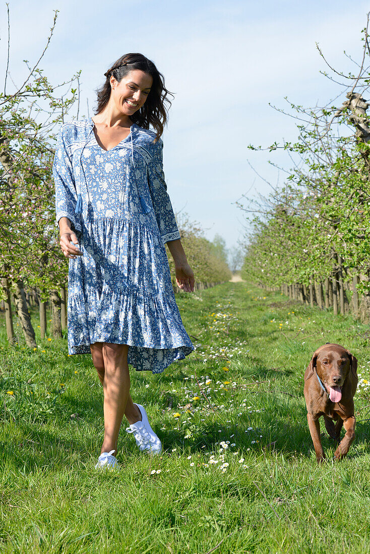 Brünette Frau mit Hund im Garten