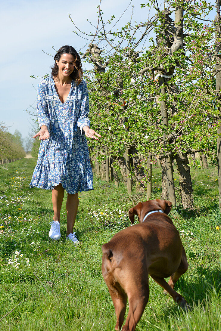 Brünette Frau mit Hund im Garten