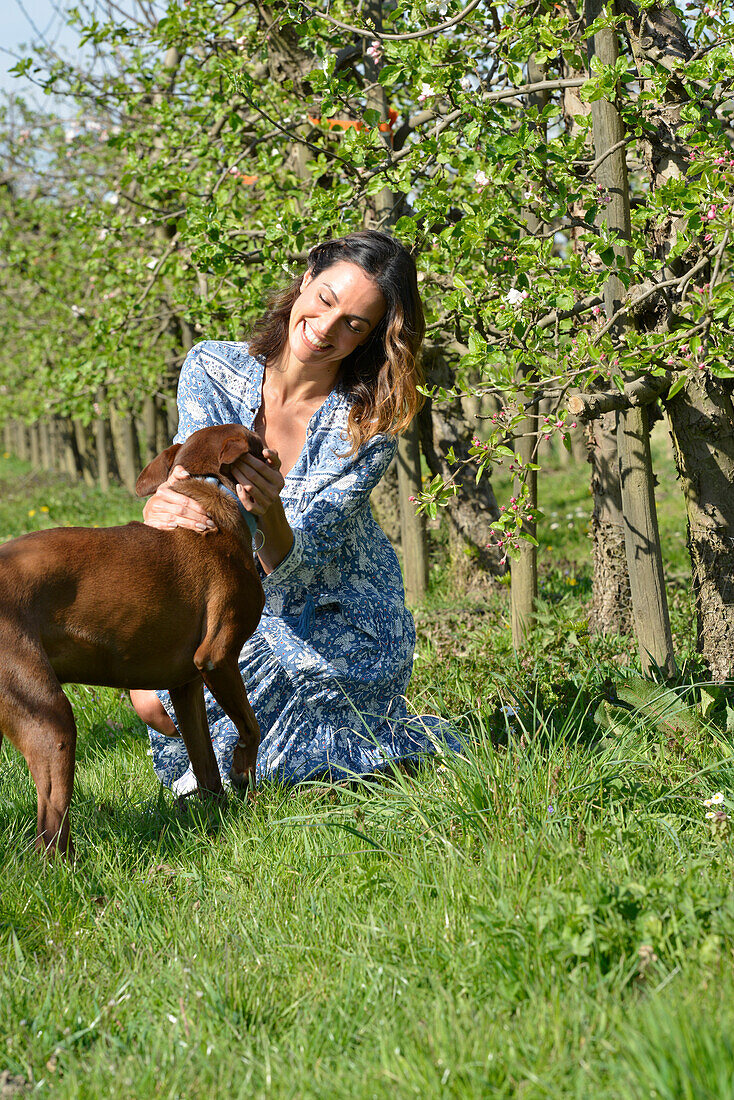 Brünette Frau mit Hund im Garten