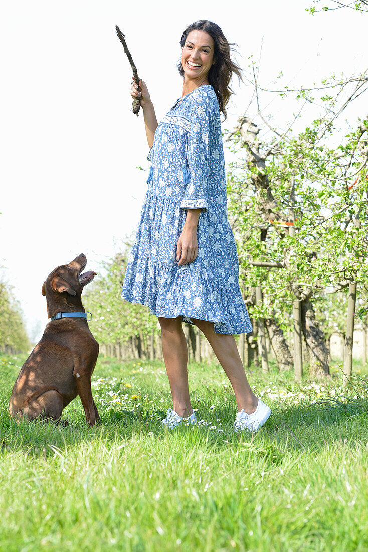 Brünette Frau mit Hund im Garten