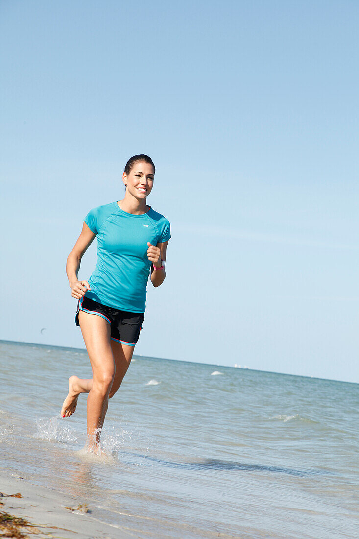 Young woman jogging by the sea