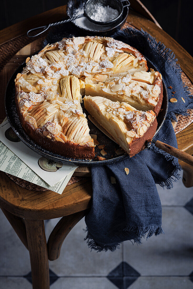 Apple cake, flaked almonds and powdered sugar