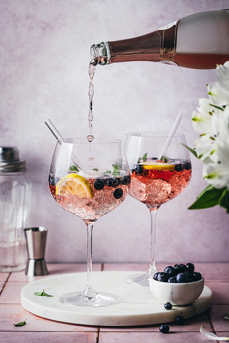 Blueberry Gin Spritz mit Eis, frischen Heidelbeeren, Minze und Zitronenscheiben