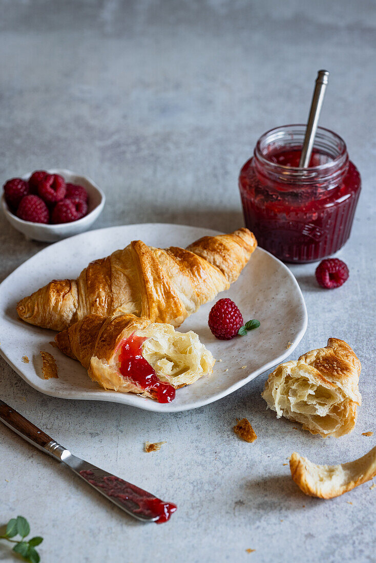 Croissants mit Himbeermarmelade und frischen Himbeeren