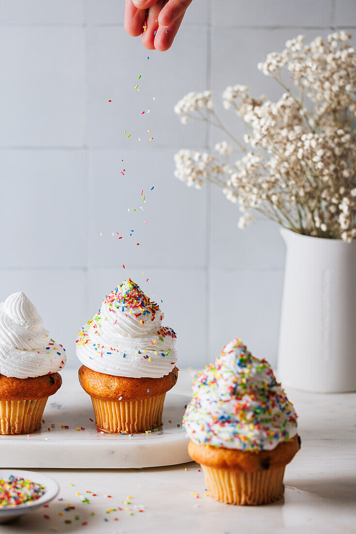 Cupcakes mit Vanillefrosting und Zuckerstreuseln