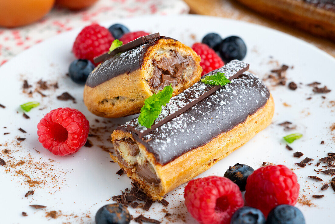 French eclair filled with chocolate cream and berries