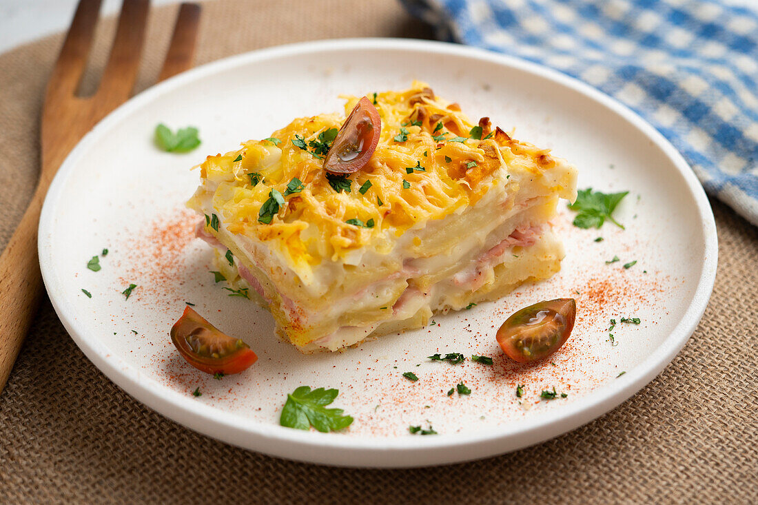 Potato pie with béchamel sauce, ham and cheese