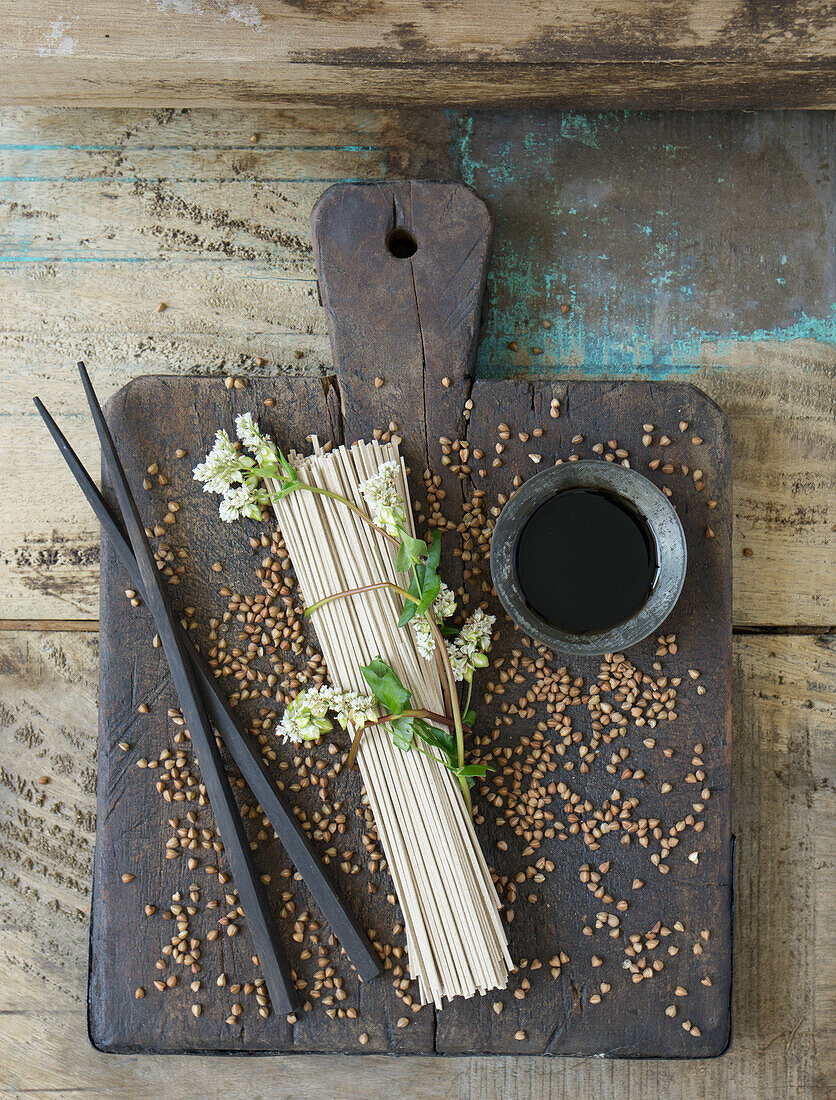 Uncooked buckwheat noodles (soba noodles) with flowering buckwheat twig