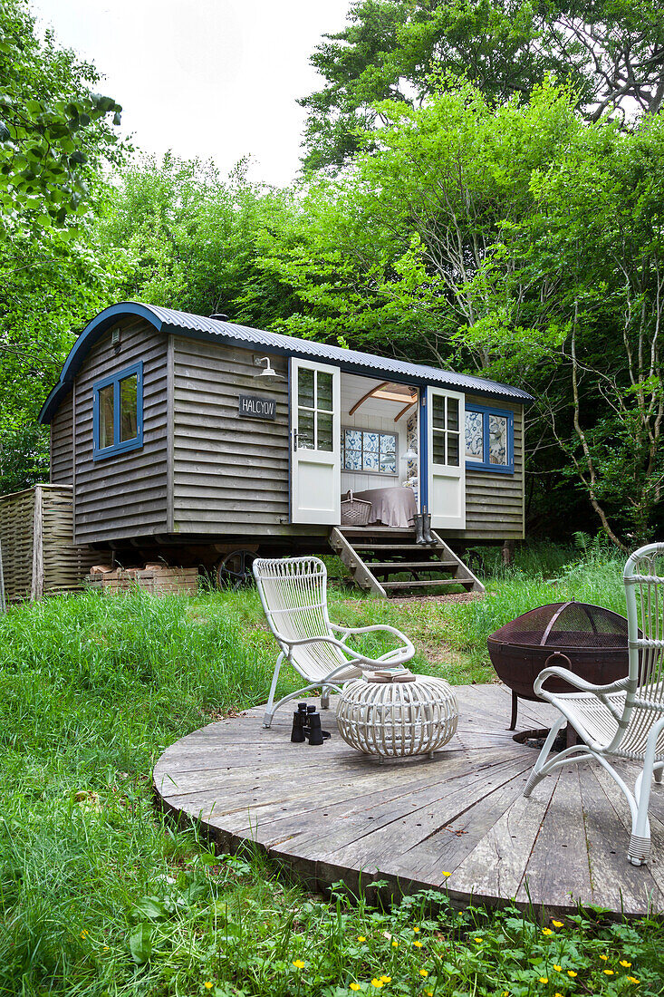 Tiny house in the forest with round terrace and garden furniture