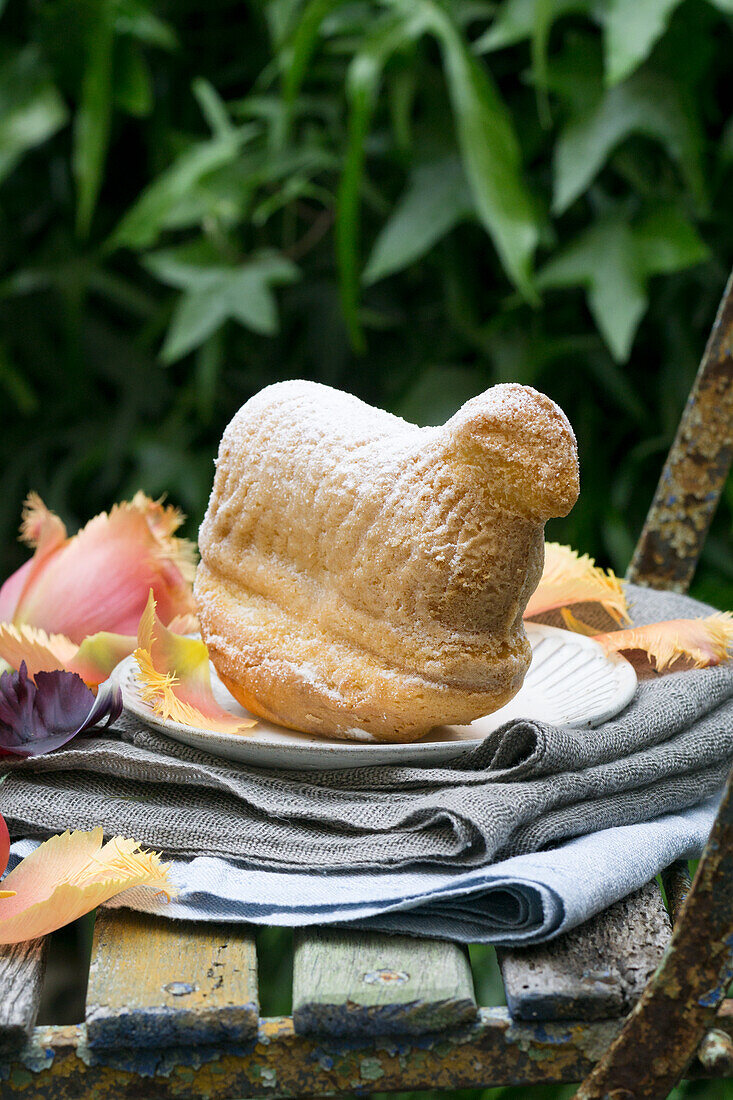 Gebackenes Osterlamm auf Terrassentisch mit Blumendekoration