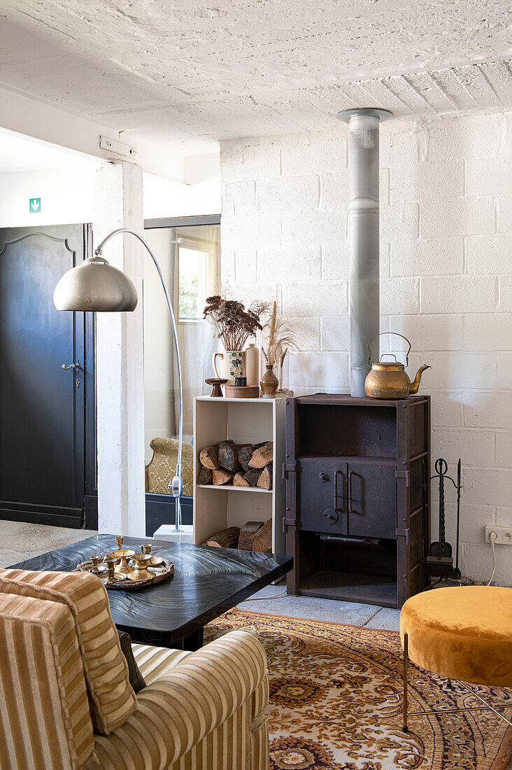 Living room with cast-iron stove, shelf and patterned carpet