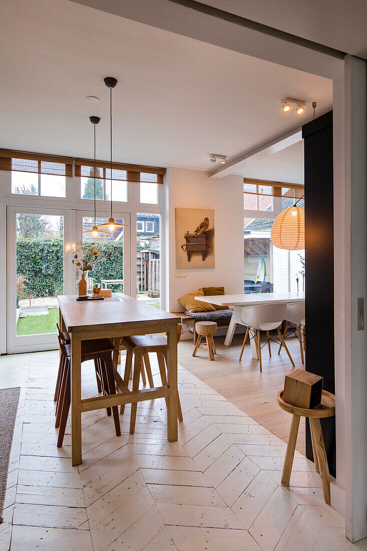 Bright dining area with wooden table and modern chairs, view of the garden