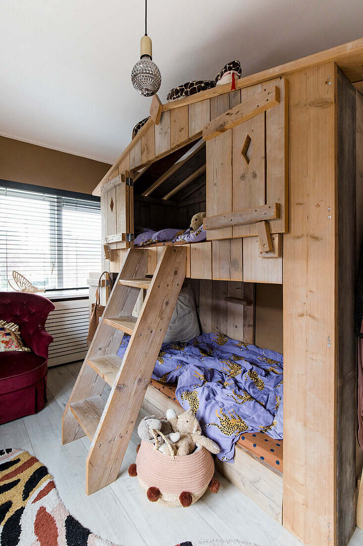 Wooden loft bed with ladder and disco ball in the children's room