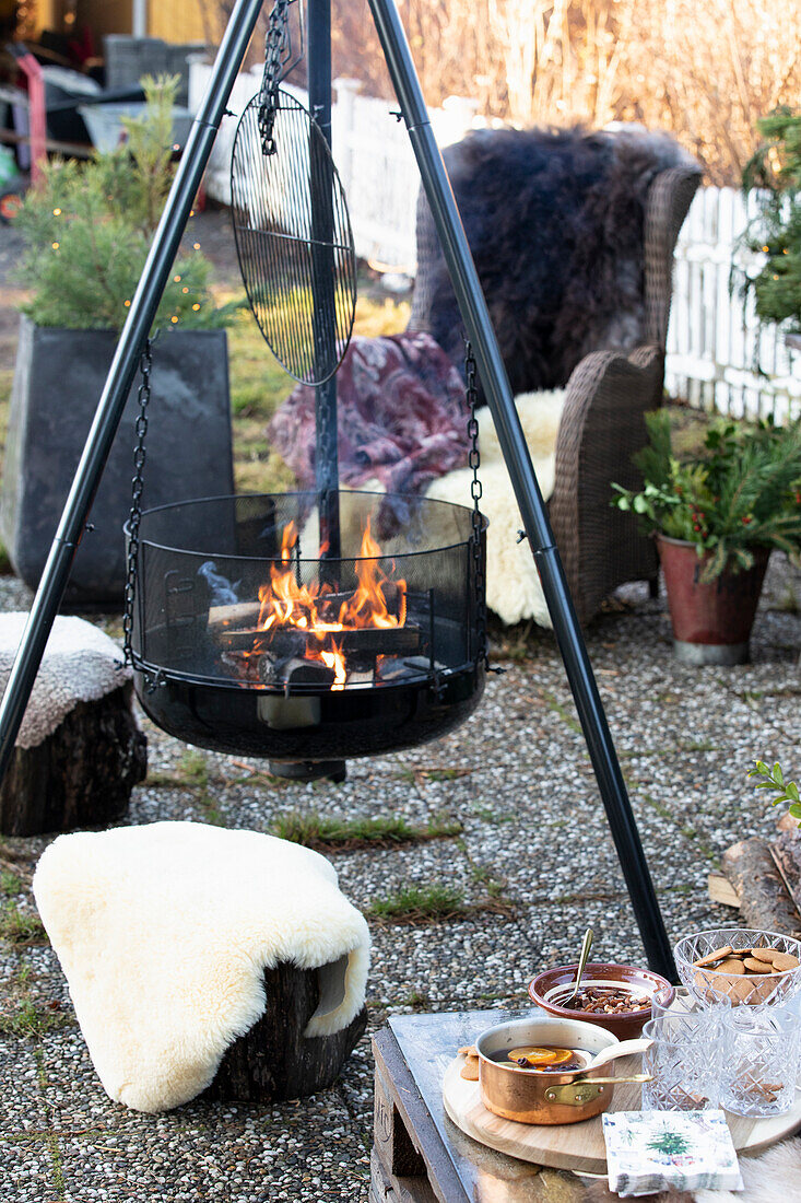Fire pit in the garden, stools and armchairs with furs
