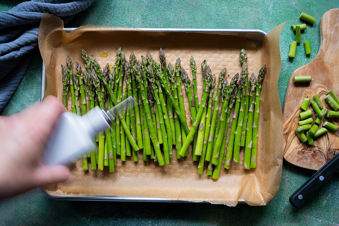 Drizzling green asparagus spears with oil