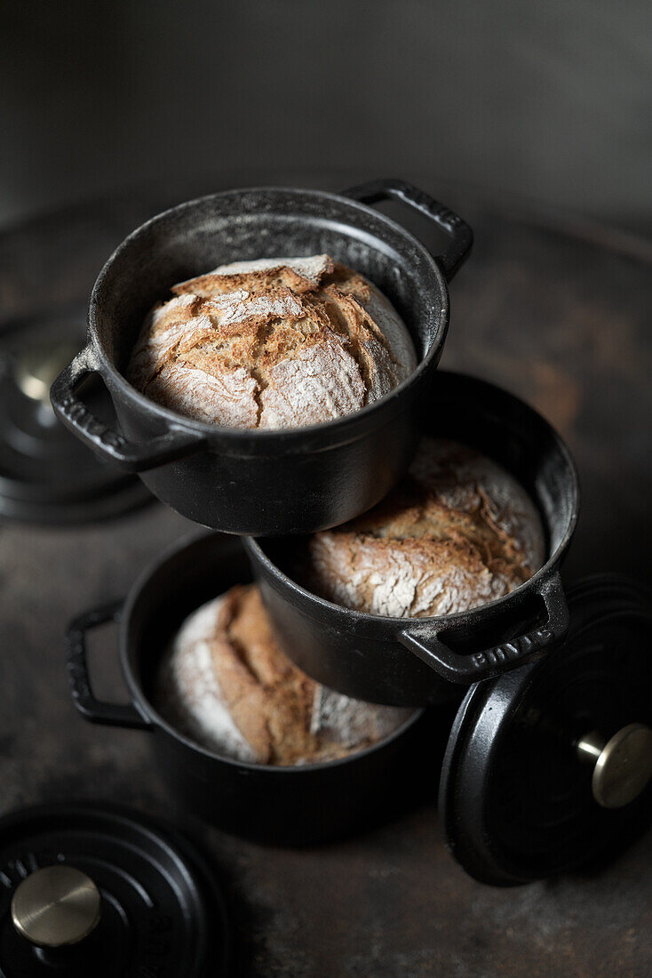 Small country bread loaves baked in cast iron pots