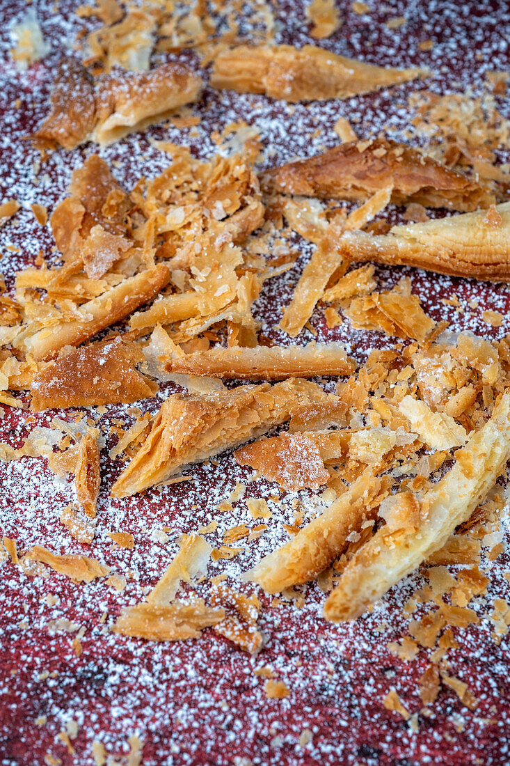 Puff pastry crumbs and confectioner's sugar on a red background