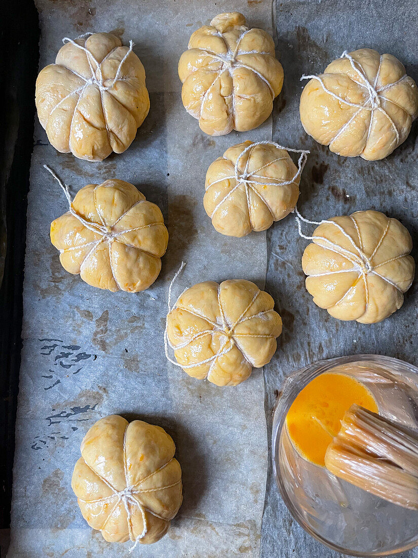 Stuffed mini pumpkin breads made from yeast dough for Halloween (unbaked)